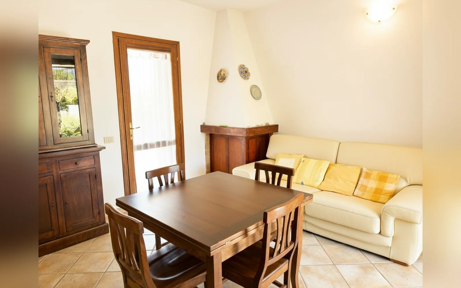 La zona pranzo con tavolo in legno e divano