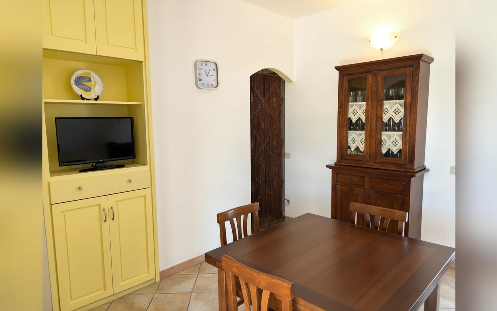 L'angolo pranzo con TV e credenza in legno