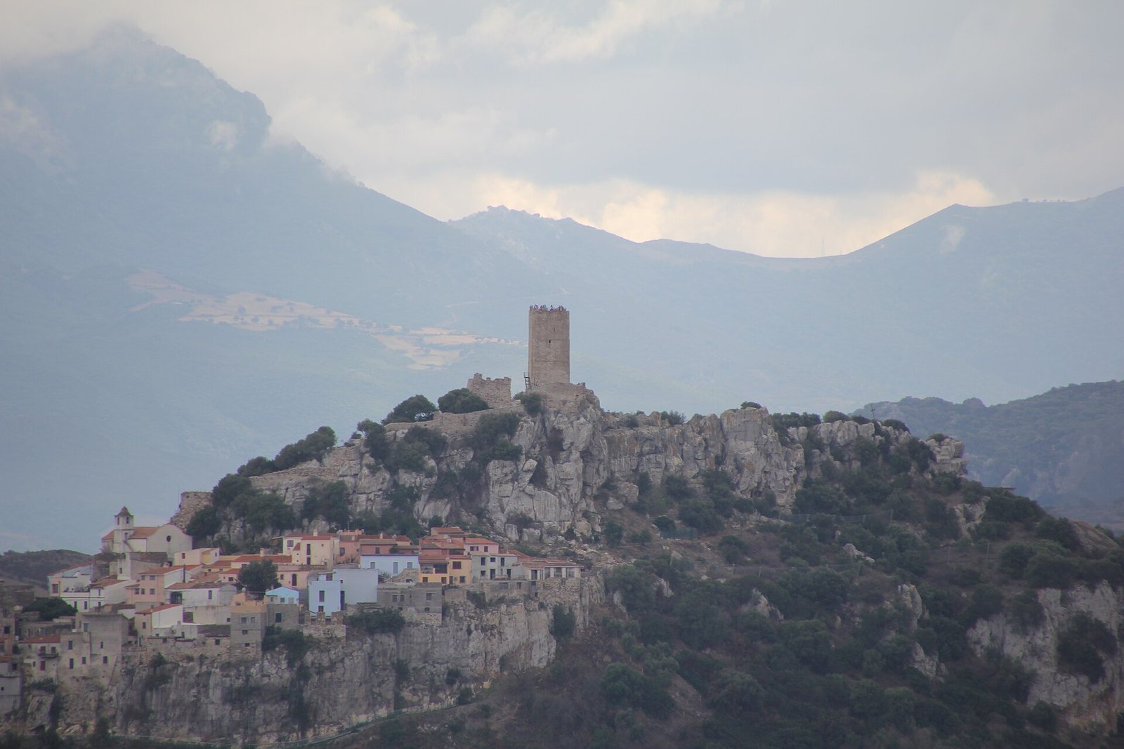 Il borgo di Posada con la torre del castello e le montagne sullo sfondo